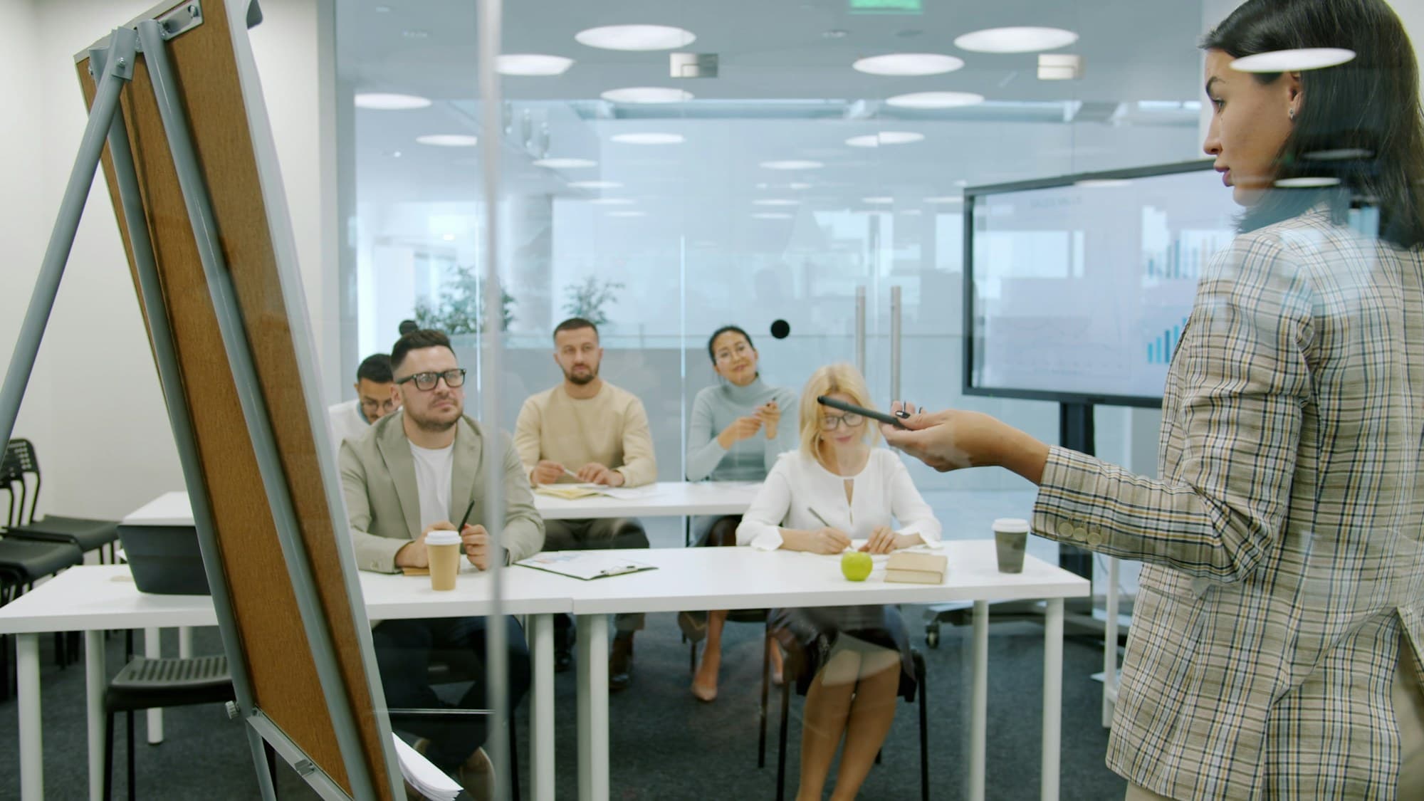 An instructor leading a small-group staff training at a whiteboard